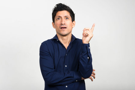 Portrait of Hispanic businessman having idea and pointing up