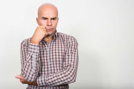 Portrait of stressed bald businessman thinking and looking downの写真素材