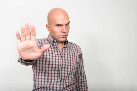Portrait of stressed bald businessman with stop gestureの写真素材