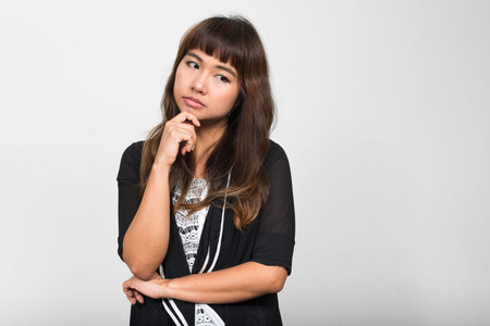 Portrait of stressed young Asian woman thinking