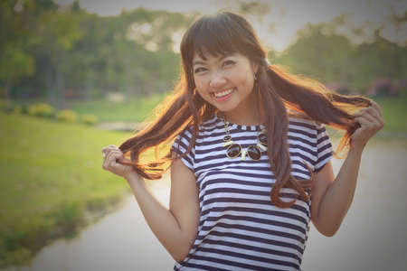 Happy young beautiful Asian woman smiling at the parkの写真素材