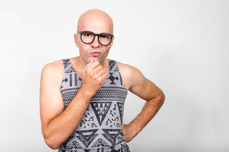 Portrait of bald nerd man with eyeglasses thinkingの写真素材