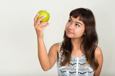 Portrait of young beautiful Asian woman holding appleの写真素材