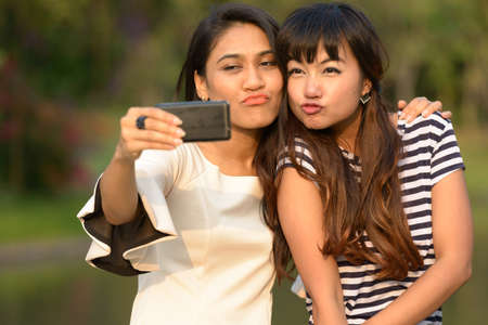 Portrait of two young Asian women together at the parkの写真素材