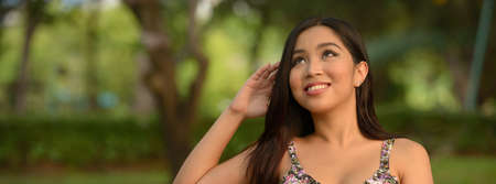 Portrait of young beautiful Asian woman at the park outdoorsの写真素材