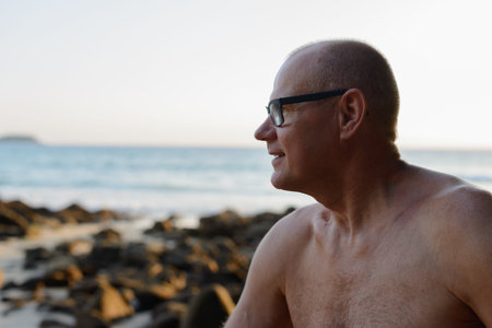 Mature handsome tourist man shirtless at the beach
