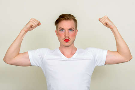 Portrait of young man with beard stubble wearing makeupの写真素材