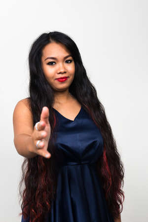 Portrait of young Asian woman against white backgroundの写真素材