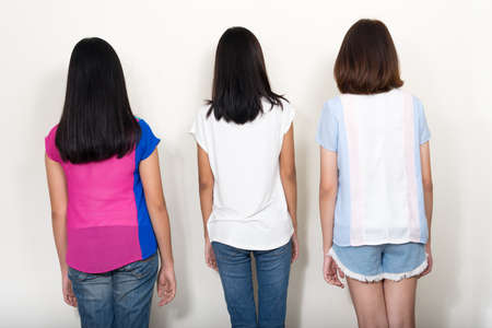 Portrait of three young beautiful Asian teenage girls as friends together, rear viewの写真素材
