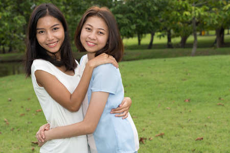 Portrait of two young Asian teenage girls as friends together at the parkの写真素材