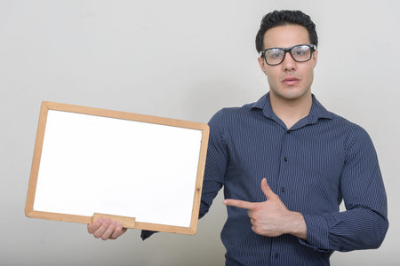 Portrait of young handsome businessman against white background