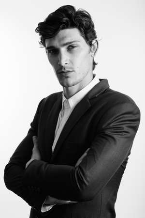Studio shot of young handsome businessman with arms crossedの写真素材