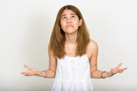 Portrait of young Asian woman against white background
