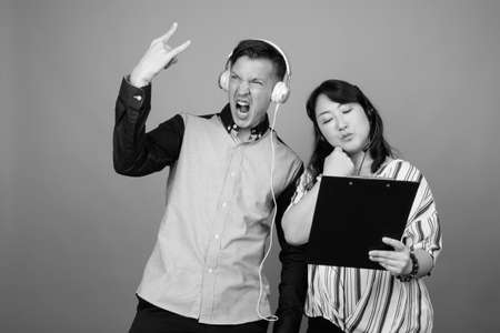 Portrait of young handsome businessman and mature Asian businesswoman togetherの写真素材