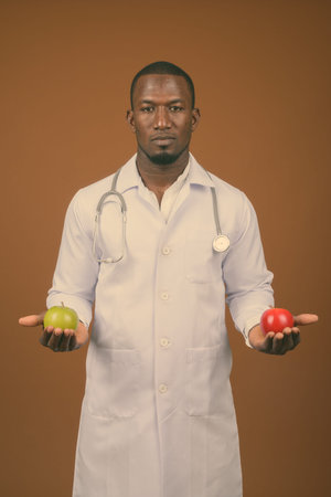 Handsome African man doctor against brown background