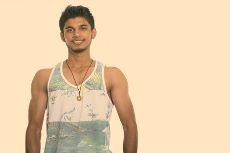 Studio shot of muscular happy Indian man smiling