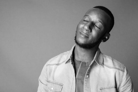 Portrait of young handsome bearded African man in casual clothing