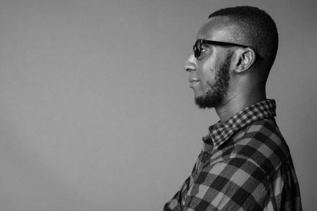 Portrait of young handsome bearded African hipster man with eyeglasses