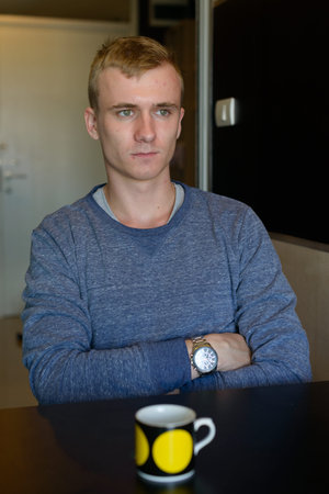 Portrait of young man with blond hair relaxing at home