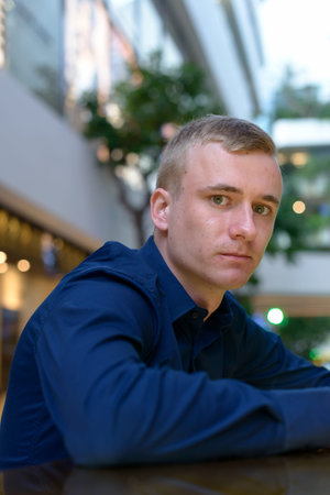 Portrait of young blond businessman inside the shopping mall