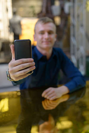 Portrait of young blond businessman inside the shopping mallの写真素材