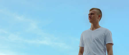 Portrait of young blond man against view of the clear skyの写真素材