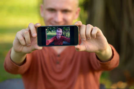 Young man with blond hair at the park outdoorsの写真素材