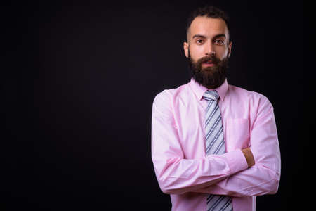 Young handsome Persian businessman with dreadlocks against black backgroundの写真素材