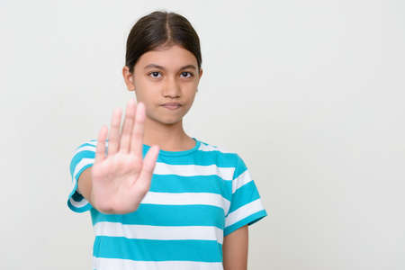 Portrait of young Asian teenage girl against white backgroundの写真素材