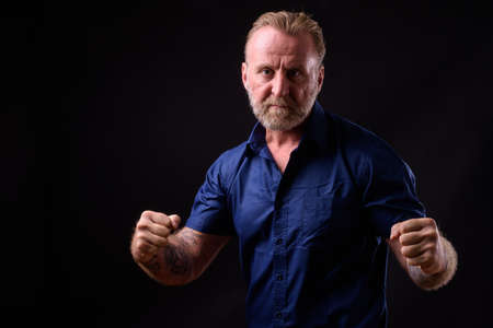 Mature handsome bearded man with blond hair against black backgroundの写真素材