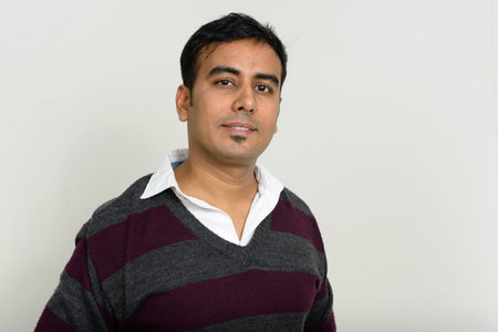 Portrait of handsome Indian man against white background