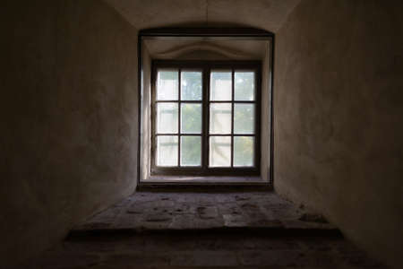 Closed vintage window cemented on brick wall with natural view and sunlight streaming inの写真素材