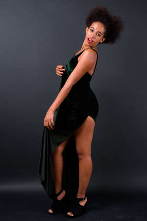 Young beautiful African woman with Afro hair against black backgroundの写真素材