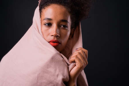 Young beautiful African woman with Afro hair against black backgroundの写真素材