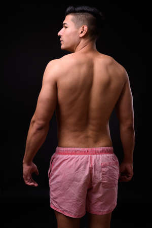 Young handsome muscular man shirtless against black backgroundの写真素材