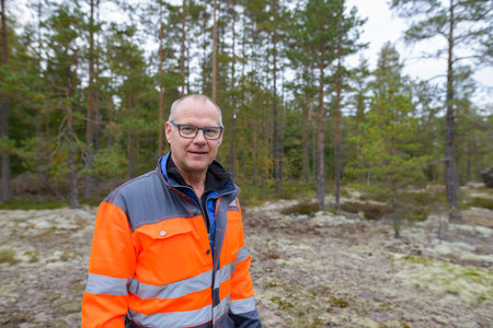 Portrait of happy mature handsome man standing in the forest