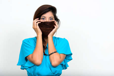 Portrait of young beautiful businesswoman covering face with hairの写真素材