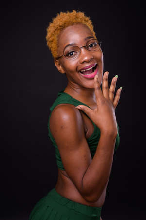 Young beautiful African woman against black backgroundの写真素材