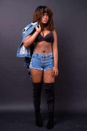 Young beautiful African woman against black backgroundの写真素材
