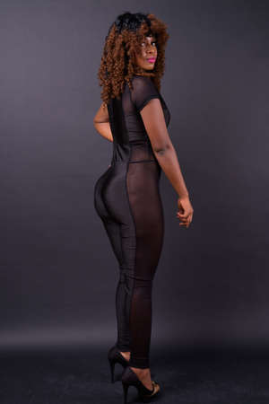 Young beautiful African woman against black backgroundの写真素材