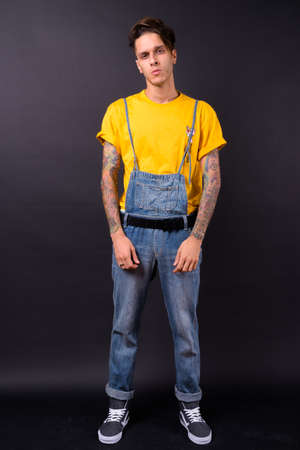 Young handsome rebellious man against black backgroundの写真素材