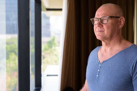 Senior handsome Scandinavian man inside the room by the windowの写真素材