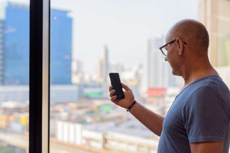 Senior handsome Scandinavian man inside the room by the windowの写真素材