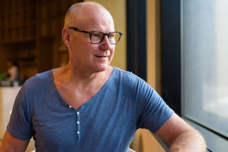 Senior handsome Scandinavian man relaxing inside the coffee shopの写真素材