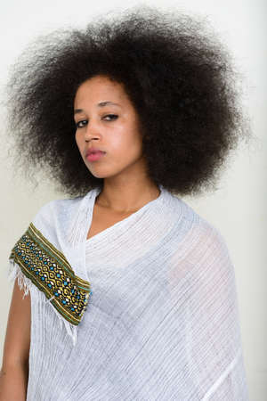 Portrait of young beautiful African woman with Afro hair in traditional clothingの写真素材