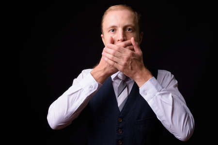 Businessman with blond hair against black backgroundの写真素材