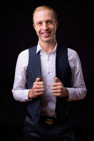 Businessman with blond hair against black backgroundの写真素材