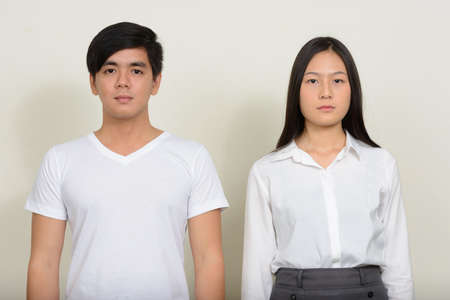 Portrait of young Asian couple together against white backgroundの写真素材