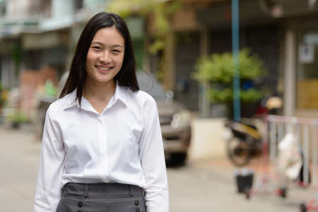 Portrait of young beautiful Asian businesswoman outdoorsの写真素材