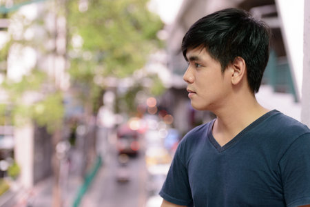 Portrait of young handsome Asian man in the cityの写真素材